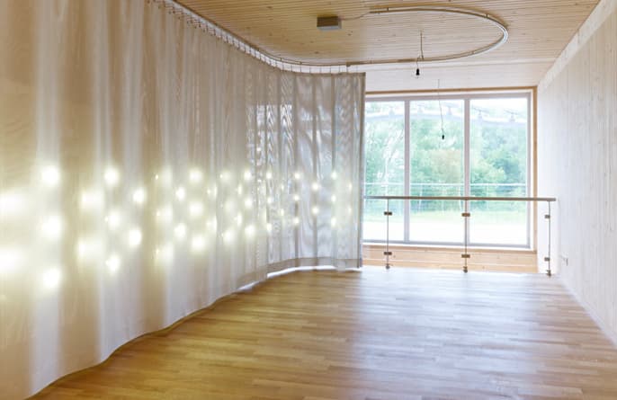 Middle level: the curtain pulled back along the wall, opening the room to the windows.