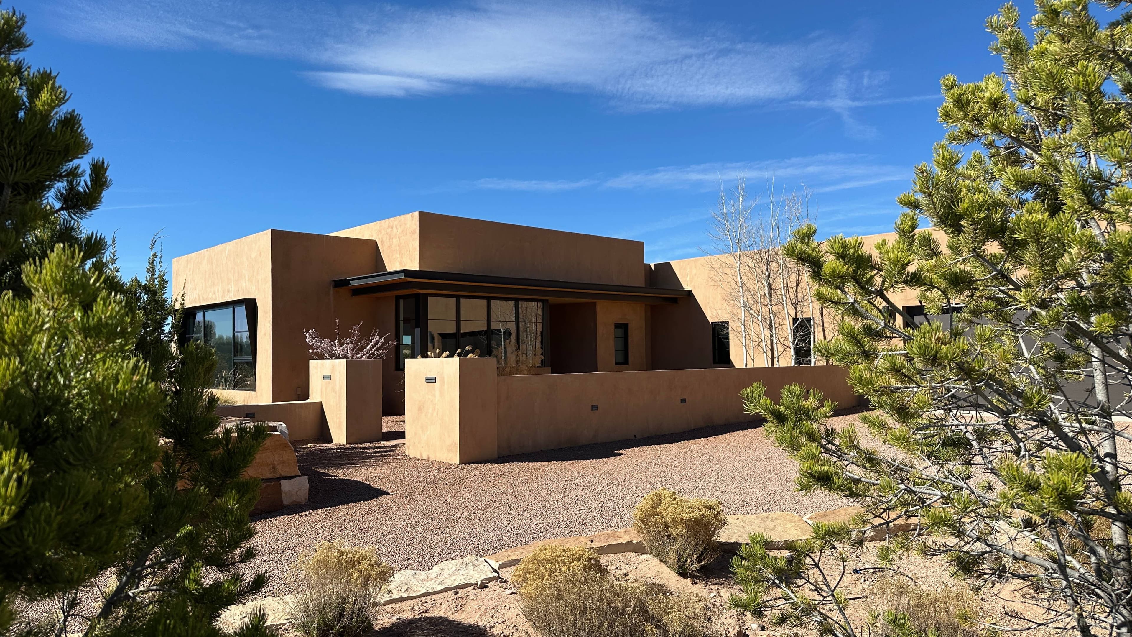 Entry elevation under clear sky, desert landscaping in the foreground.